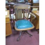 Early XX Century Oak Revolving Office Chair, with rail supports, shaped arms, upholstered seat, on