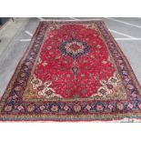 An Iranian Tabriz Wool Carpet, with central floral medallion within elaborate borders in mainly red,