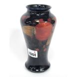 A Moorcroft Pottery Vase, of baluster form, painted in the 'Pomegranate' pattern against a dark blue