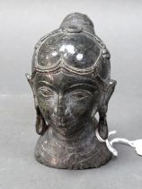 A Carved Stone Head and Shoulders Bust of an African Female, with large drop earrings, her hair tied