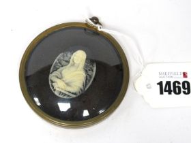 A XX Century Oval Cameo, carved as the Mona Lisa against a black ground, mounted in a gilt metal