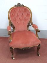 A Mid XIX Century Walnut Armchair, the top rail with 'C' scroll carving and scroll arms on carved