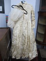 A Mid XX Century Cream Brocade Wedding Gown, with fitted bodice fastened to the front with pearl