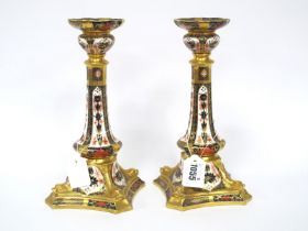 A Pair of Royal Crown Derby Porcelain Candlesticks, the shaped square bases moulded with dolphins,