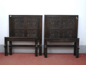 A Pair of Oak Single Beds, the backboards with four floral carved panels.