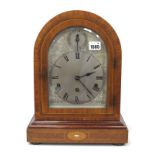 An Early XX Century Mahogany Cased Mantle Clock, the arched case inlaid in satinwood and mother of