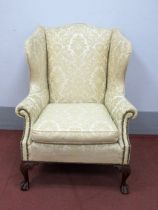 A Georgian Style Wing Chair, upholstered in floral damask with stud decoration to arms, on carved