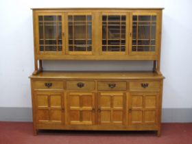 Alan Grainger 'Acorn Man'; An Oak Dresser, the top with four glazed cupboard doors, the base with