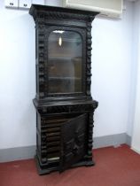 A XIX Century Carved Oak Bookcase, with a stepped cornice over carved lion heads, glazed door with