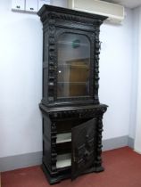 A XIX Century Carved Oak Bookcase, with a stepped cornice over carved lion heads, glazed door with