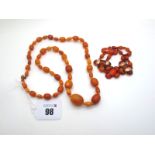 A Single Strand Graduated Amber Coloured Bead Necklace, together with a vintage amber coloured