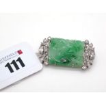 An Art Deco Style Diamond and Jade Set Panel Brooch, the engraved and pierced rectangular panel claw