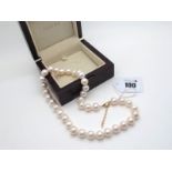 Iliana; A Modern Pearl Bead Necklace, 38 uniform beads knotted to clasp (stamped "750"), 45.5cm