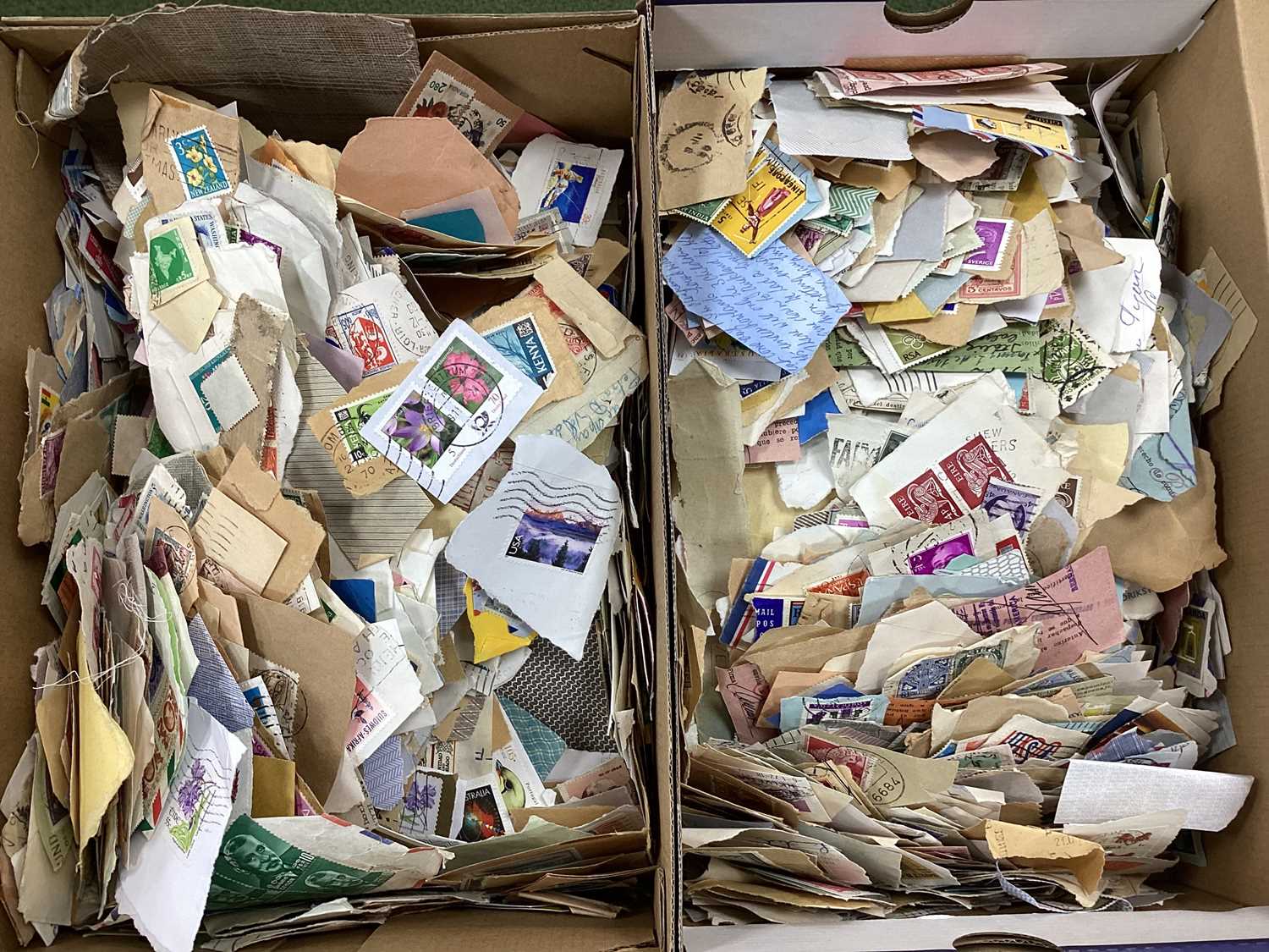 Two shoeboxes containing world stamps 'on paper', includes some earlier items from around 1940's