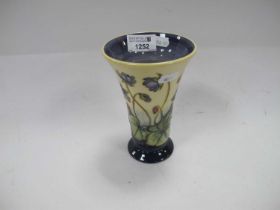 Moorcroft Pottery Vase, featuring violets on cream ground, of fanned form, 15.5cm high.