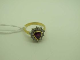 An 18ct Gold Ruby and Diamond Cluster Ring, collet rubover set to the centre, within border of