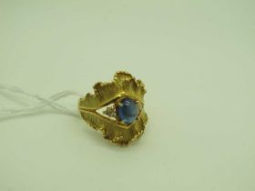 A Decorative Sapphire and Diamond Dress Ring, oval cabochon four claw set between six brilliant