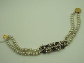 A Two Row Fresh Water Pearl Bead Bracelet, with central pierced panel, claw set as flowerheads, to