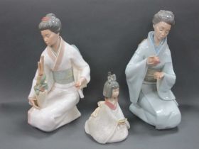 Two Nao Porcelain Figures of Japanese Ladies, one kneeling and holding a teapot and cup and