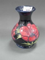 A Moorcroft Pottery Vase, painted in the 'Anemone' pattern on a deep blue ground to bulbous body,