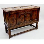 An antique oak coffer carved lozenges and arches to front all raised on stand with square