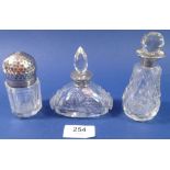 A cut glass toiletry bottle with silver and silver gilt hammered lid, London 1898 and two cut
