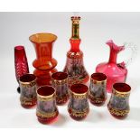 An Italian red glass decanter and glasses set, a cranberry glass jug and two other red glass vases