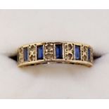 A yellow metal eternity ring set baguette cut sapphires interspersed with pairs of chip diamonds,