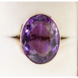 A 9 carat gold handmade large oval cut Brazilian amethyst ring with deep engraved band setting