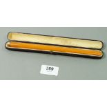 A 9 carat gold mounted long amber cigarette holder in fitted case