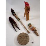 A collection of wooden items to include a Folk Art monkey toy, carved nut crackers, thistle butter