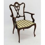 An Edwardian mahogany framed Chippendale style open armchair on cabriole supports