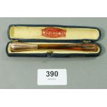 A gold mounted amber cheroot holder, cased by W H Newman, pipe makers, 12cm
