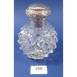 A cut glass scent bottle with silver lid, embossed flowers, London 1896, 13cm tall
