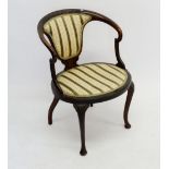 A Victorian mahogany framed tub chair with carved top rail, upholstered back and oval seat