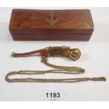 A reproduction brass Bosun's whistle in wooden box