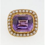 A small yellow metal brooch set amethyst within seed pearl surround, 17mm x 15mm