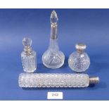 A Victorian cut glass toiletry bottle with silver lid, 21cm long and three other toiletry bottles