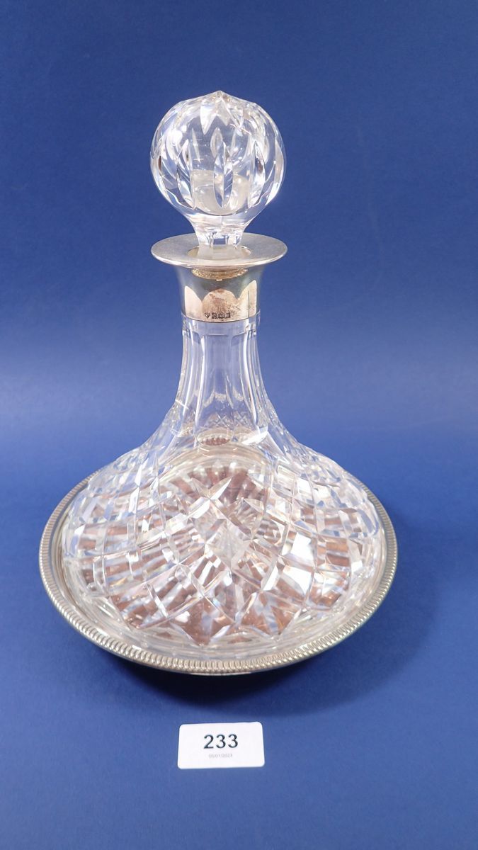 A cut glass decanter with silver collar and matching turned wood and silver stand, Birmingham 1973