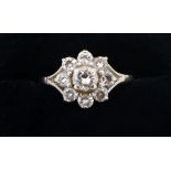 A diamond cluster ring set central stone in eight stone surround, size M to N