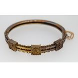 A Victorian 15 carat gold hinged bangle with applied decoration, 17g