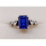 An 18ct gold ring set rectangular cut blue stone flanked by four white stones, size M to N