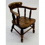 A Victorian child's elm and fruitwood bow back chair with spindle supports, 49cm tall