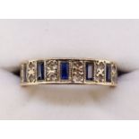 A yellow metal eternity ring set baguette cut sapphires interspersed with pairs of chip diamonds,