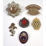 A group of badges including two cap badges, enamel nursing badge, masonic pendant and a Miracle