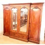 A Heals fine Victorian mahogany breakfront wardrobe with two handing robes flanking linen trays,