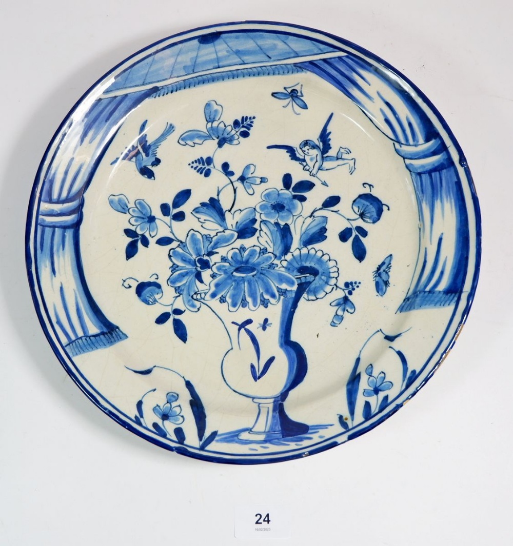 A Delft plate painted urn of flowers, 30cm