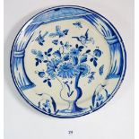 A Delft plate painted urn of flowers, 30cm