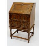 An early 20th century Jacobean style small bureau with panelled decoration and two drawers, 58cm