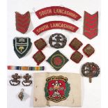 A group of South Lancashire regiment items including cap badge, collar badges, cloth shoulder